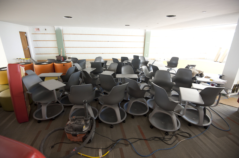 New chairs with attached desks await placement. The chairs have a basket underneath for books and packs and wheels for easy movement around the study area.
